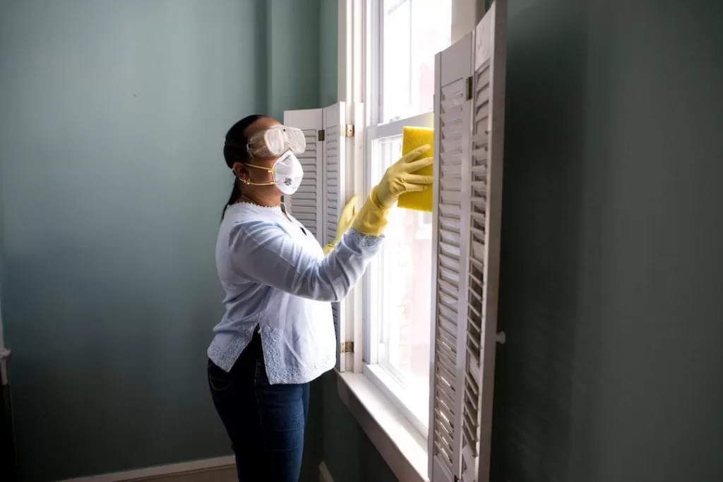 A woman in goggles and gloves cleans a window. Experts at your local pest control company have years of pest control experience backing up their services.

