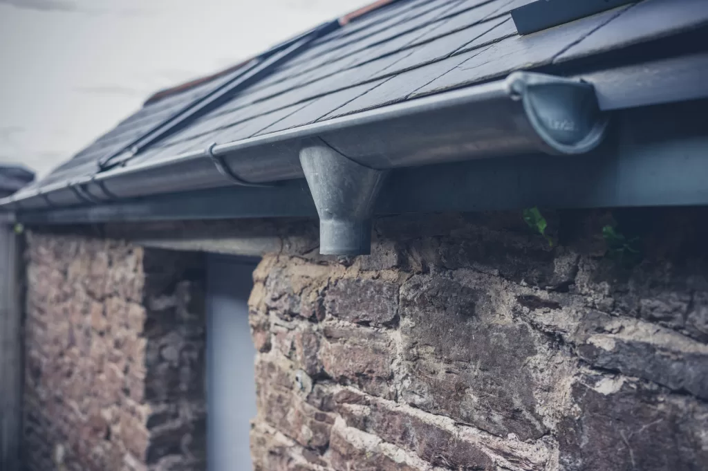 The drain and gutter on the roof of a small house