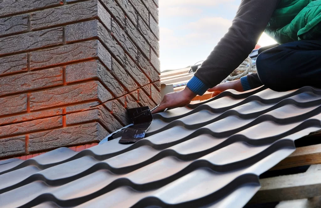 Roofer installing a bituminous tile on the roof of a house