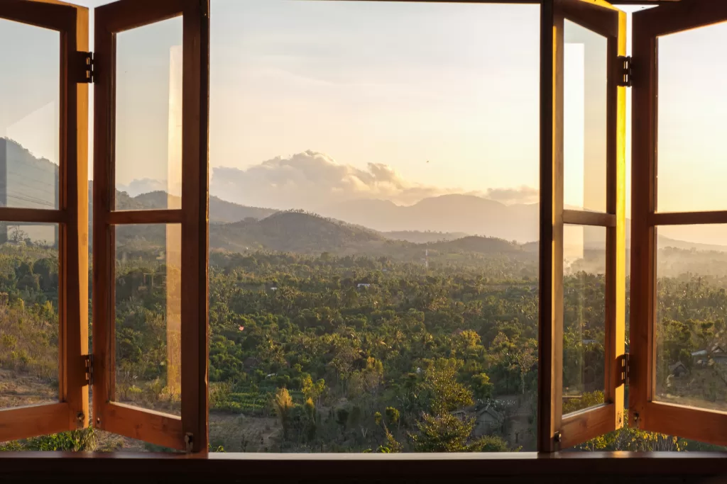 Open window showcasing a panoramic view of mountains