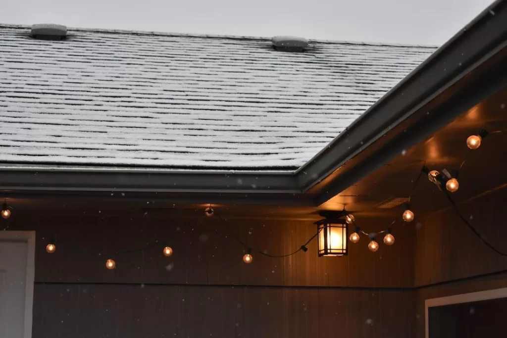 A new shingled roof on a home with lights hanging on a porch