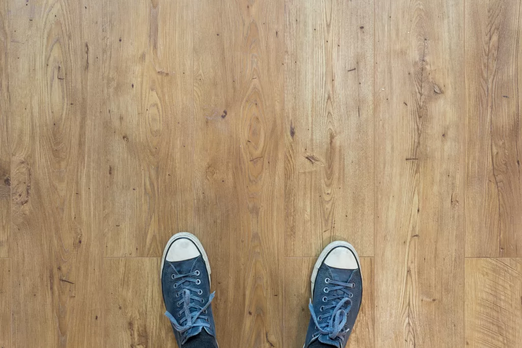 A person is standing on a beautifully laid vinyl floor