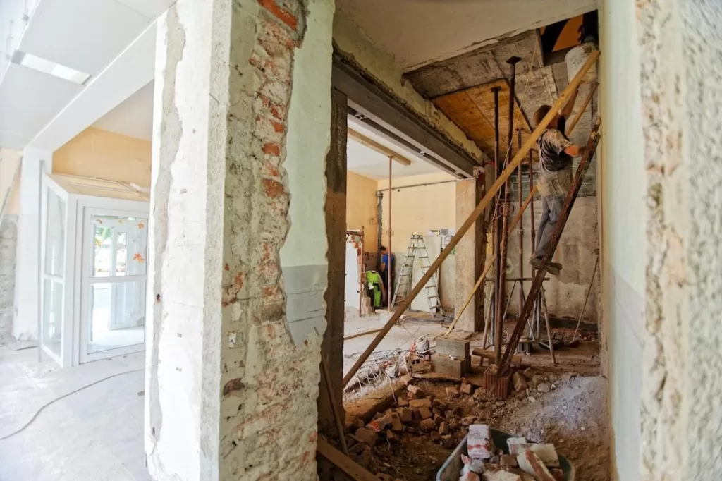 A local home remodeling company is working on a home with exposed walls and a contractor on a ladder