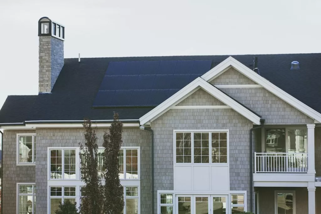 Gray home with a black roof and solar project installed by a local solar company