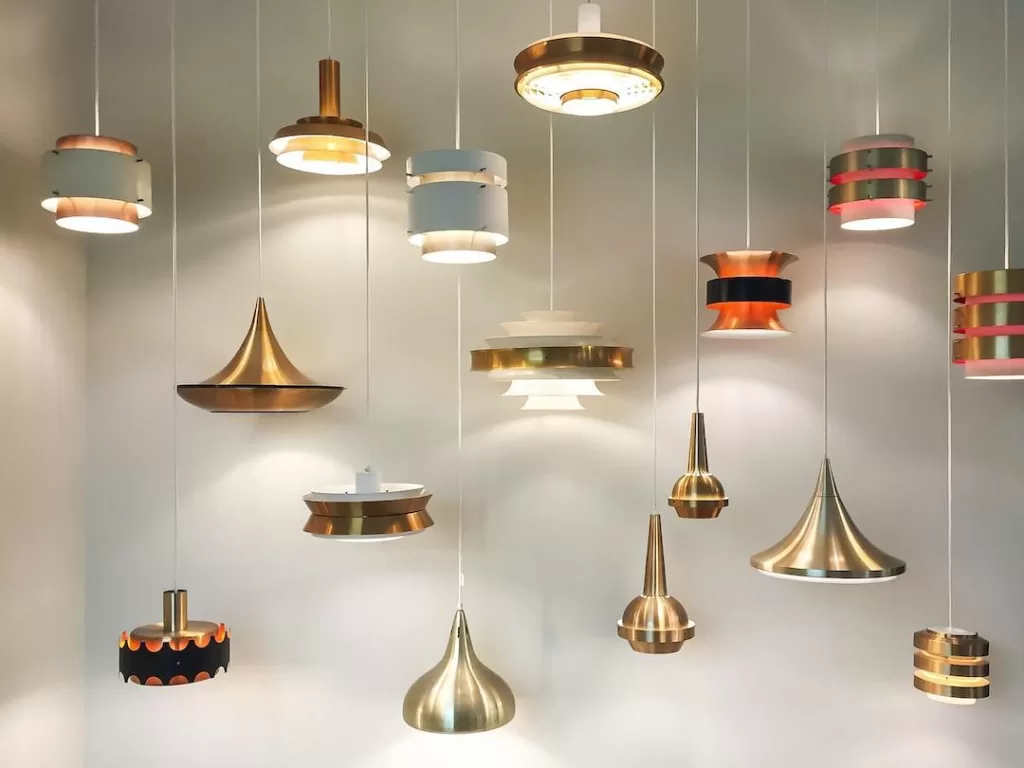 An assortment of various metallic chandeliers and lighting fixtures against a white backdrop.