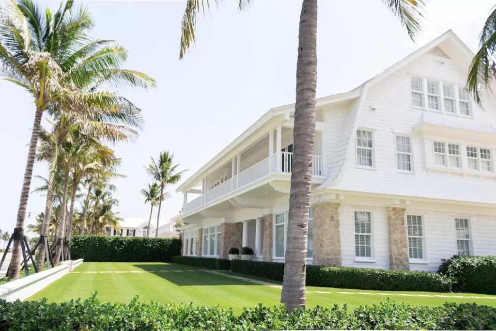 Florida home with palm trees and white shingles from a Florida roofing company