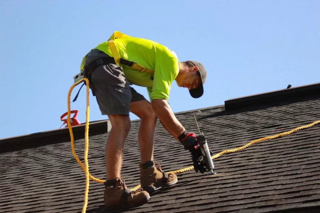  Roofer from a San Antonio roofing company repairing a broken shingle
