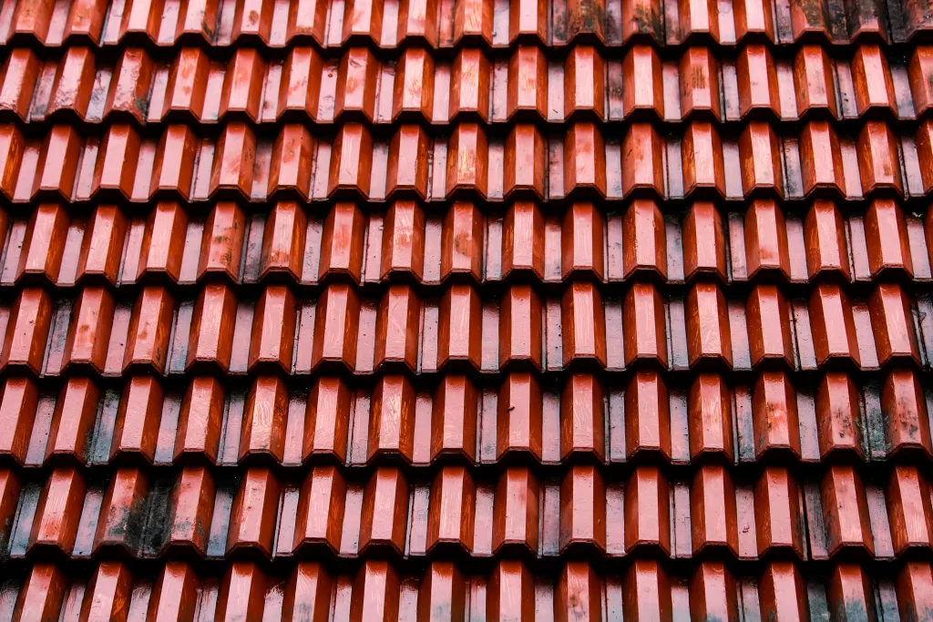 Close-up of terracotta-colored roof tiles with visible signs of wear
